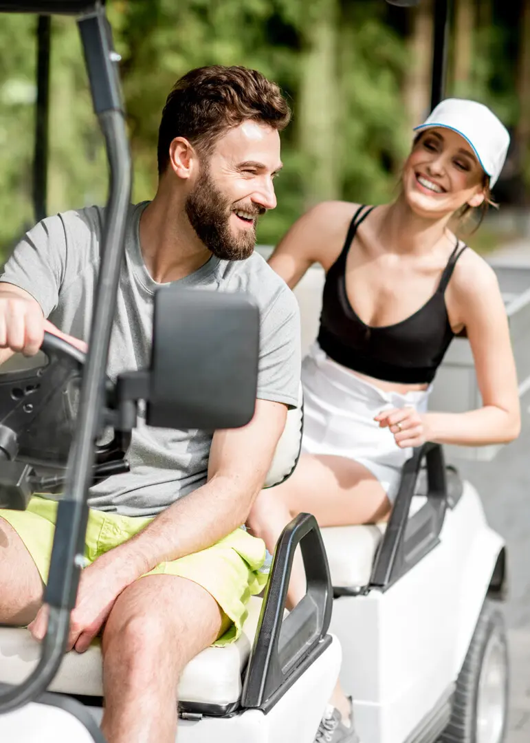 A couple riding in a golf cart